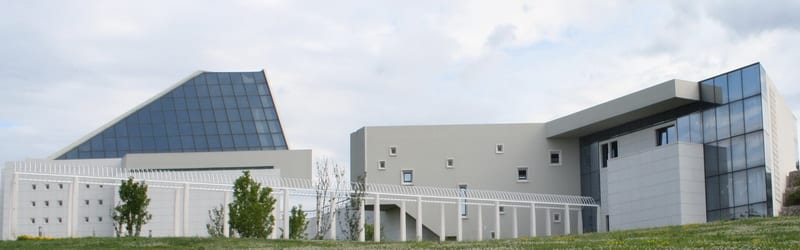 Moderna zgrada komunalnog društva KD Kozala s kosim staklenim krovom i betonskim zidovima na groblju.