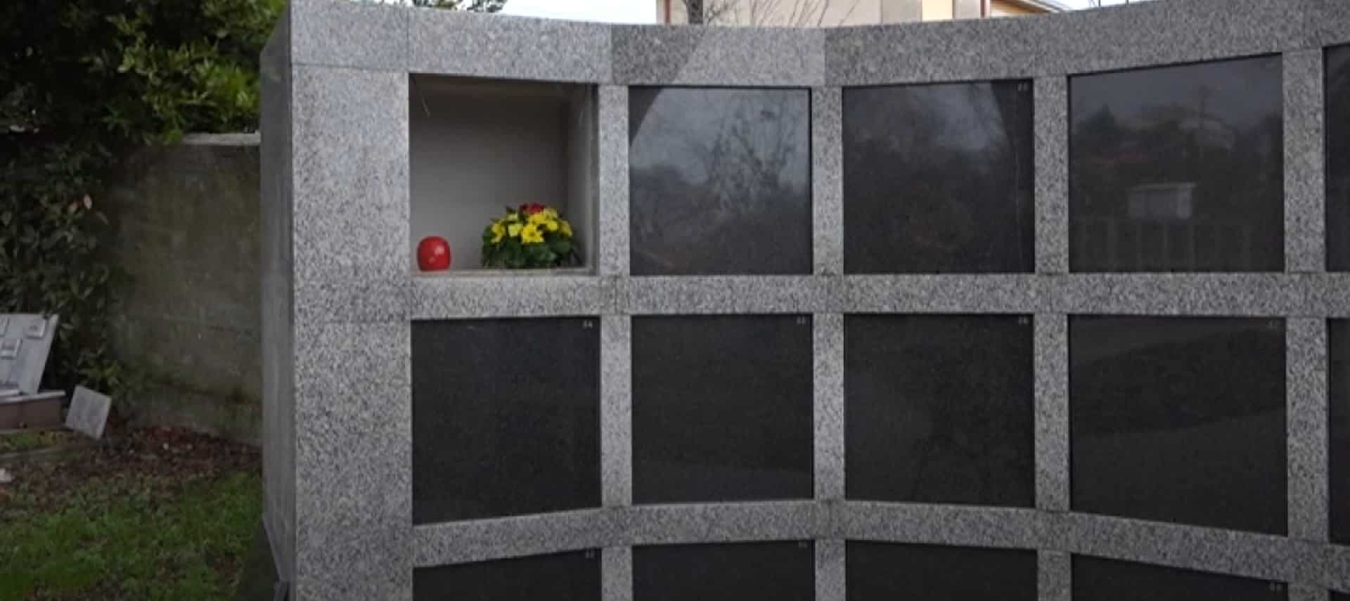 Granitni kolumbarij na groblju kućnih ljubimaca s otvorenom nišom u kojoj stoje cvijeće i svijeća