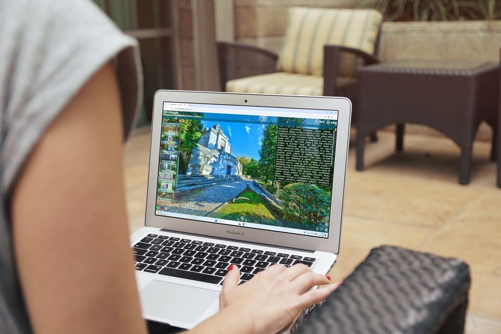 Osoba na prijenosnom računalu pregledava virtualni obilazak riječkog groblja Kozala s prikazom mauzoleja.